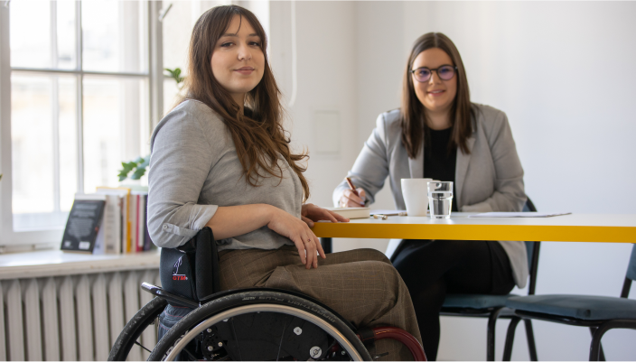 Dwie kobiety, w tym jedna na wózku inwalidzkim.